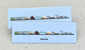Two flat, long rectangle magnets sit one on top of the other - they feature a flat back line, on top of which are small graphic illustrations of buildings and landmarks against a light blue background. Underneath the line, black bold text reads "Wearside"