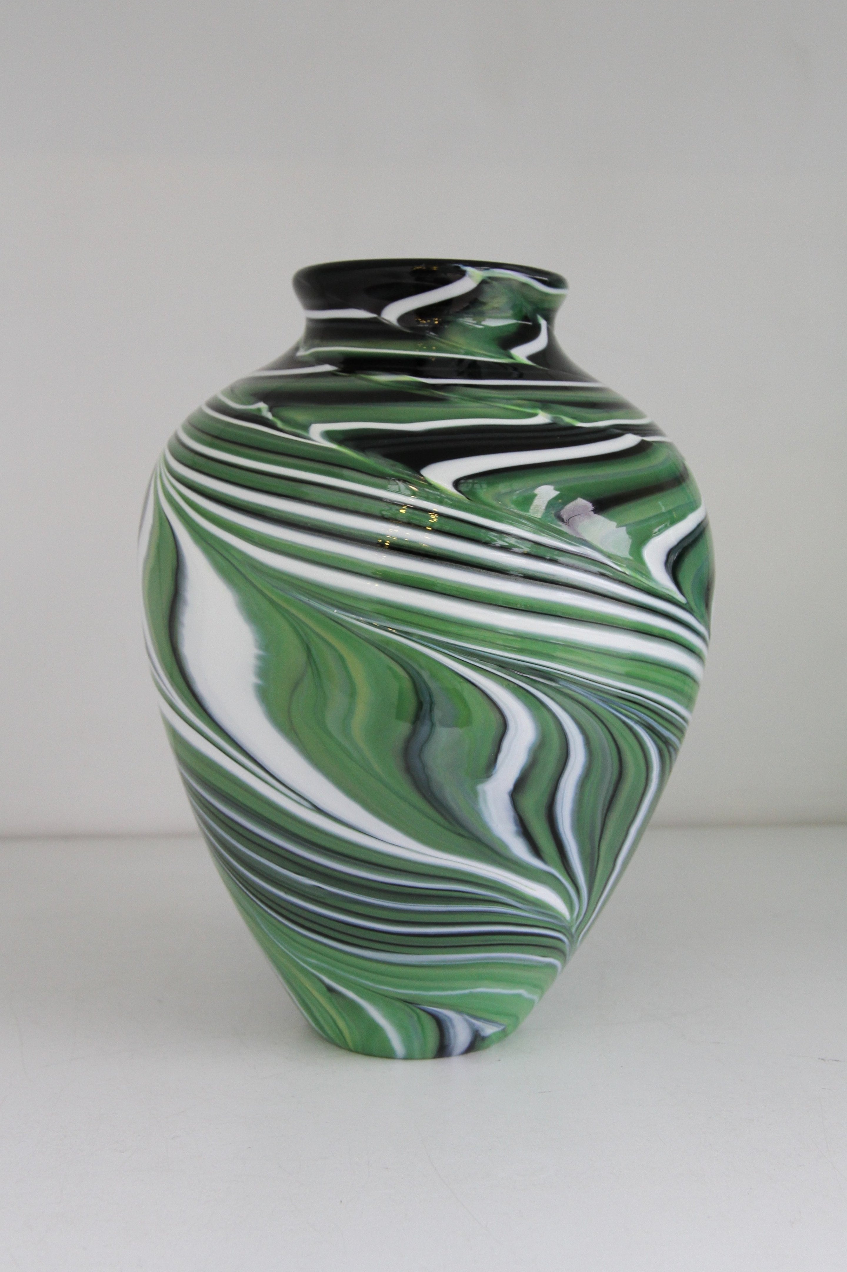 Green vase with black and white swirls