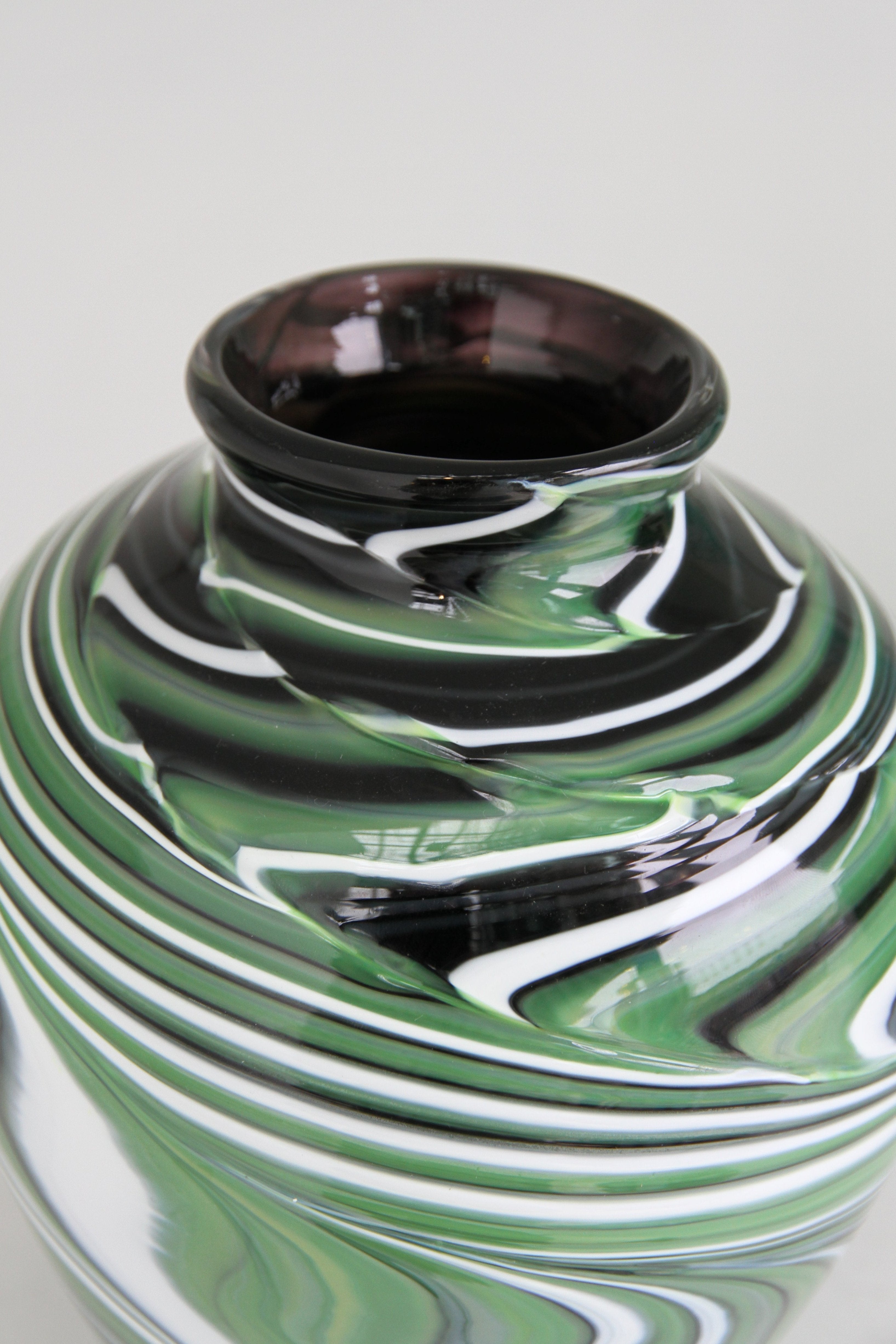 Green vase with black and white swirls