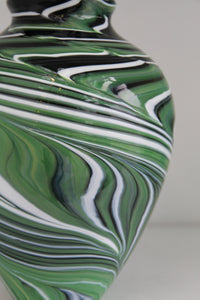 Green vase with black and white swirls